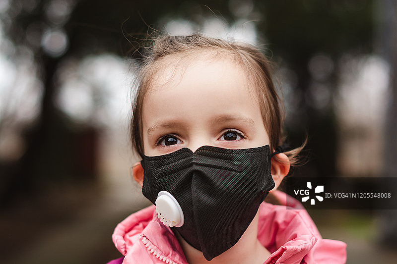 小女孩戴着污染口罩。图片素材
