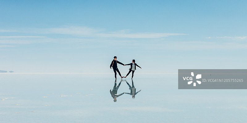 乌尤尼盐沼，一对情侣在盐滩上跳舞图片素材