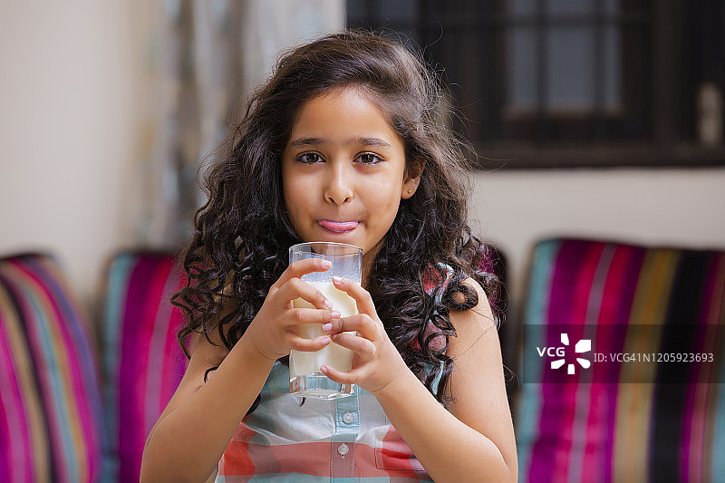 肖像一个开朗可爱的女孩微笑着拿着一杯牛奶的照片图片素材