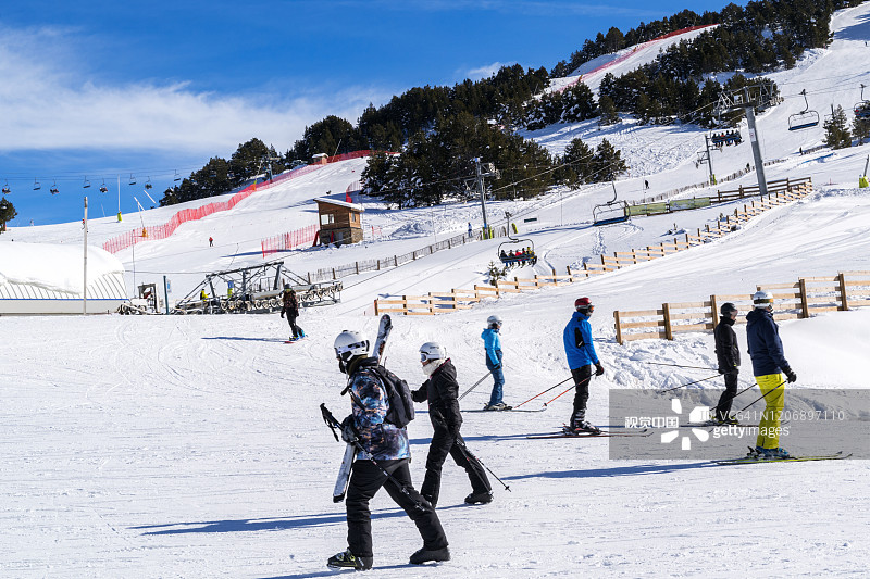 人们在安道尔比利牛斯山脉格兰德瓦利拉滑雪场的斜坡上滑雪和滑板。图片素材