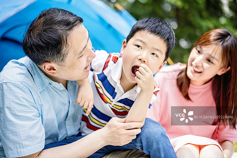 快乐的亚洲家庭在森林公园野餐图片素材