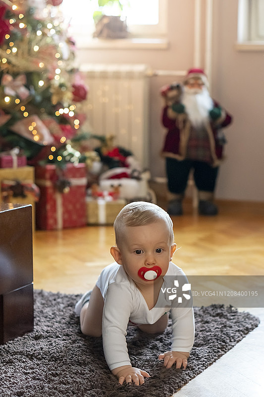 圣诞节小男孩在客厅里爬来爬去图片素材