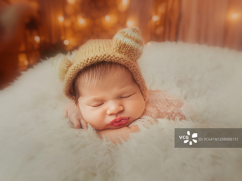 戴着滑稽帽子的新生女婴正在睡觉图片素材