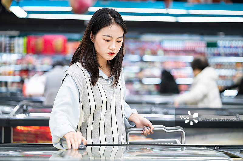 年轻女性在超市购物图片素材