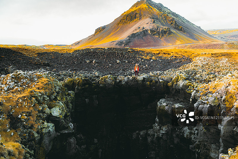 年轻女子旅行者探索冰岛日落时的风景火山景观图片素材