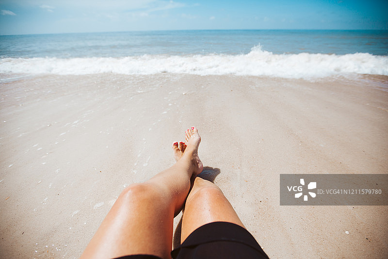 在海边晒太阳的女人的腿图片素材