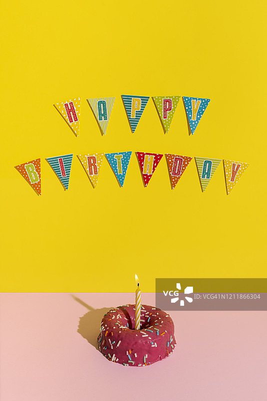 生日宴会上的彩色装饰蜡烛蛋糕图片素材