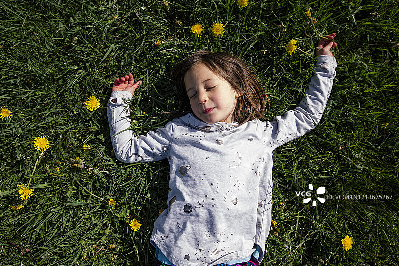 上面的观点，和平的孩子躺在田野的野花在春天图片素材