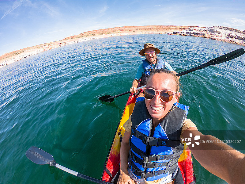 一对年轻夫妇在热带目的地的红色独木舟上自拍图片素材