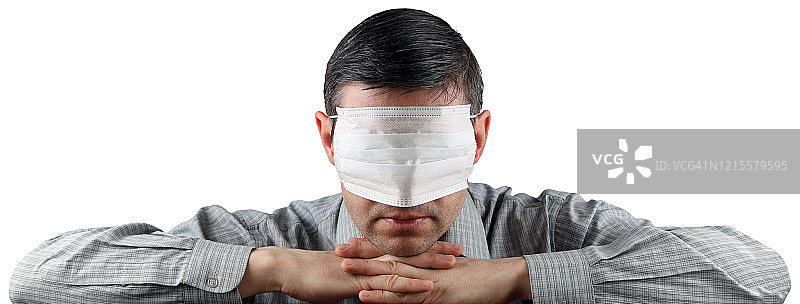 一名男子用医用口罩蒙住眼睛，孤立在白色背景下图片素材