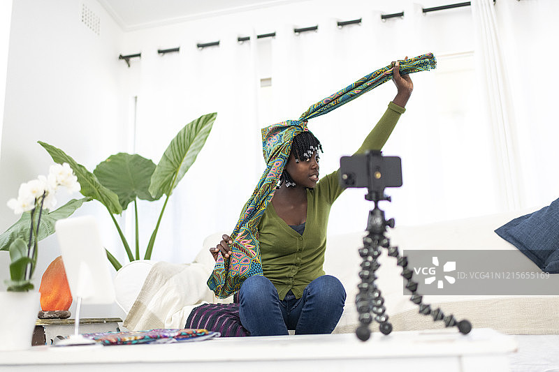 在视频教程中，宽镜头非洲影响者将材料系在头上图片素材