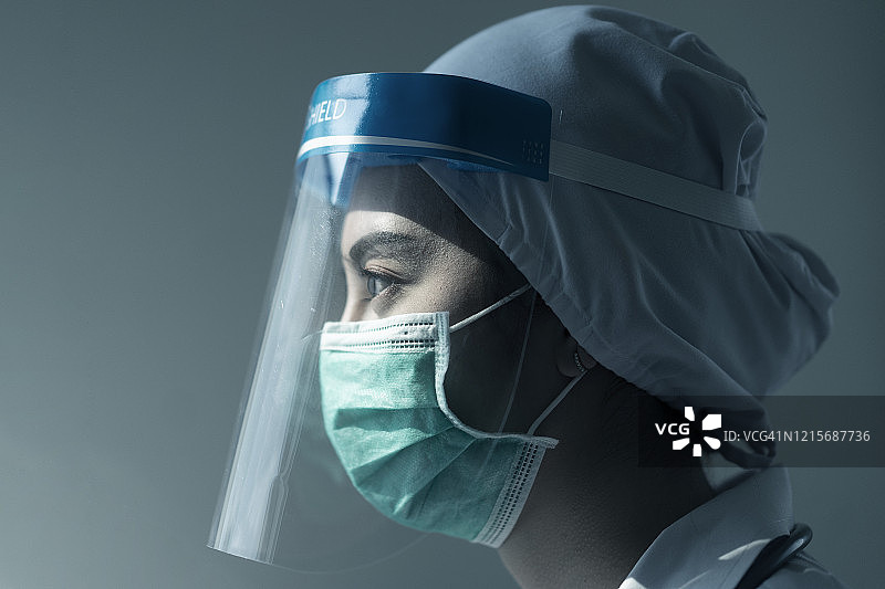 肖像亚洲女医生戴面罩和防护服，手持注射器应对冠状病毒或Covid-19疫情，Covid-19隔离的概念图片素材