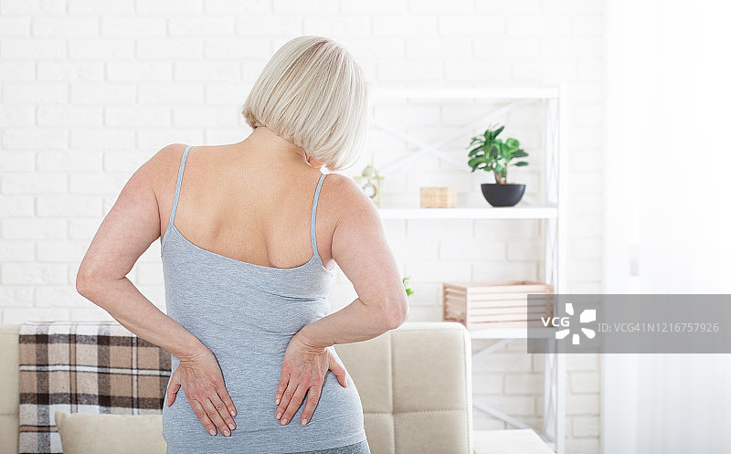 腰部疼痛的中年妇女。概念照片，标明疼痛的位置。卫生保健的概念图片素材
