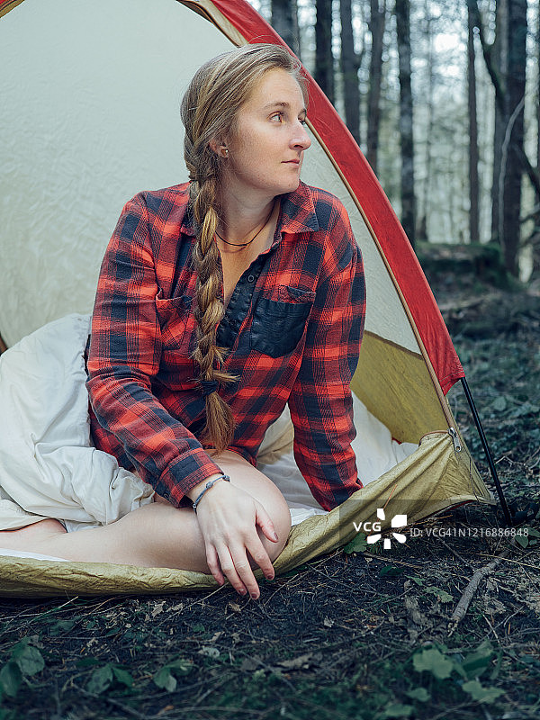 年轻的冒险女人们坐在她的帐篷里望着太平洋西北雨林图片素材