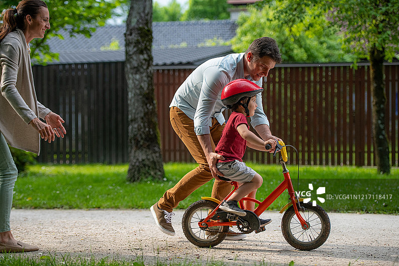 父亲教儿子骑自行车图片素材