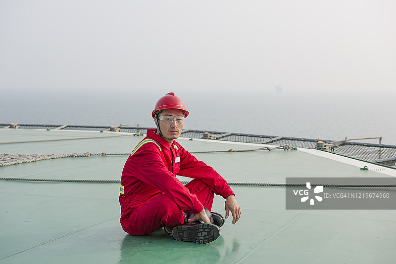 在海上石油钻塔上的生活。海上石油钻井工人在直升机甲板上图片素材