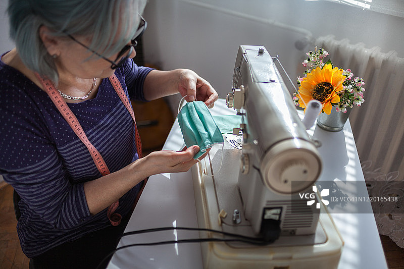 在家里用缝纫机干活的妇女图片素材