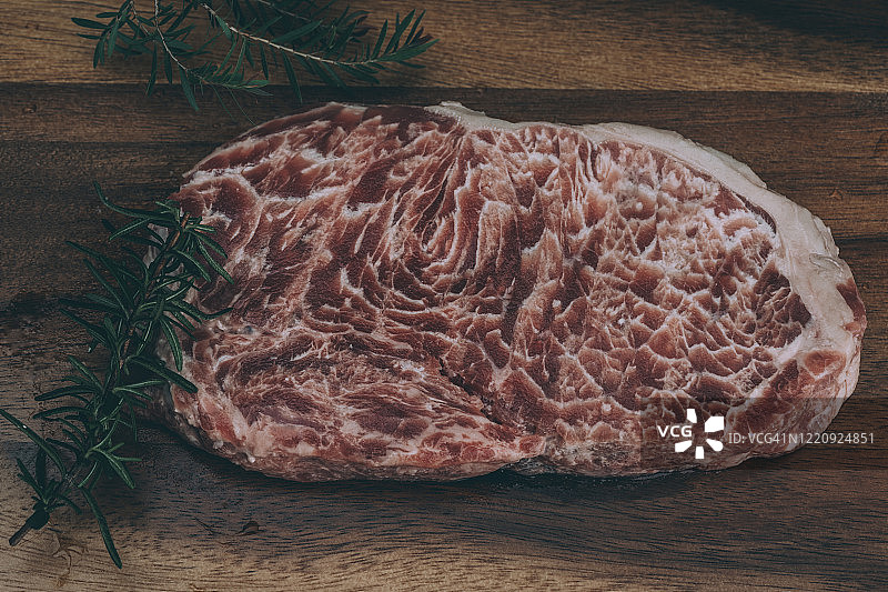 用切肉刀和调味料放在木板上的生肋眼牛排图片素材