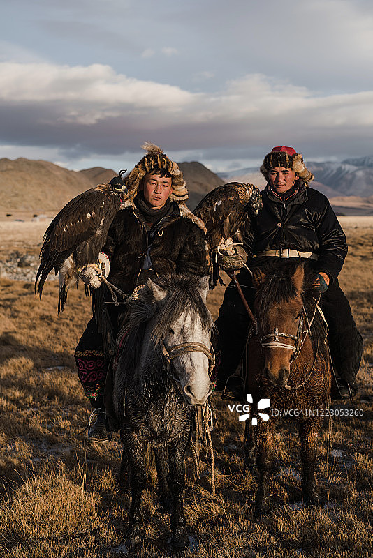 两个猎鹰者在蒙古河边图片素材