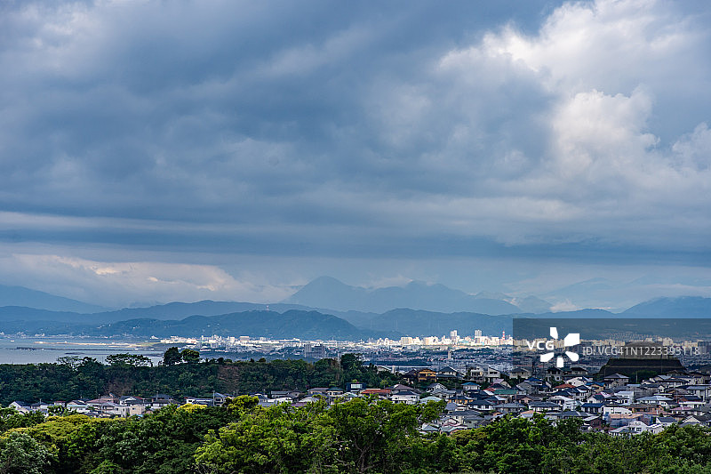 日本神奈川县山上和海边居民区上的雨云图片素材