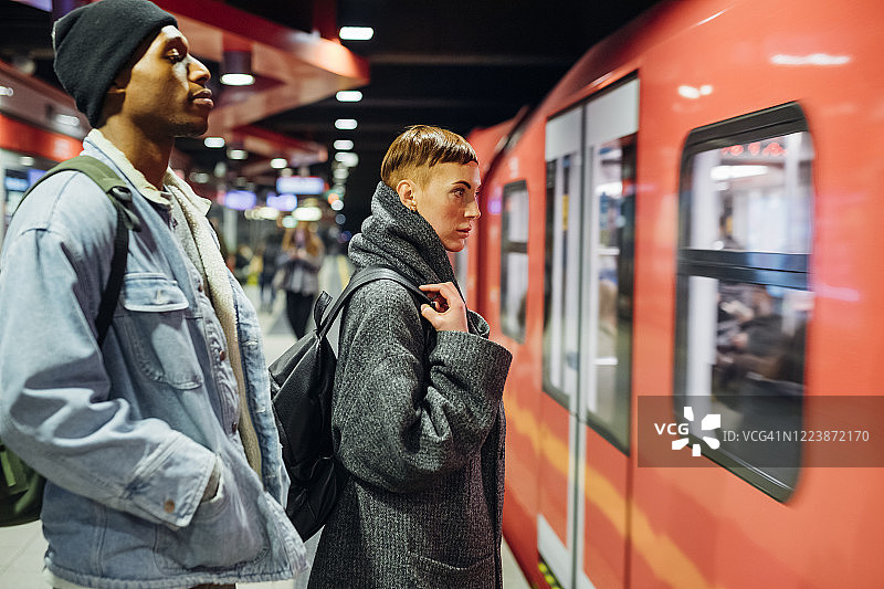 一对年轻夫妇站在地铁站站台上图片素材