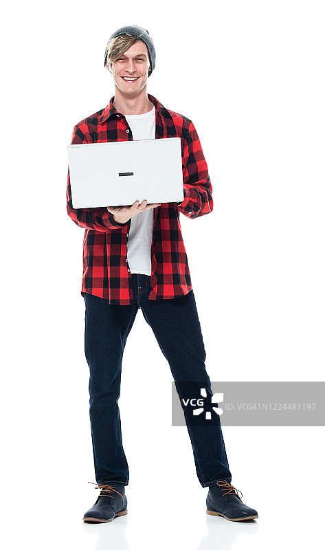 白人男性潮人站在白色背景下穿着纽扣衬衫和使用电脑图片素材