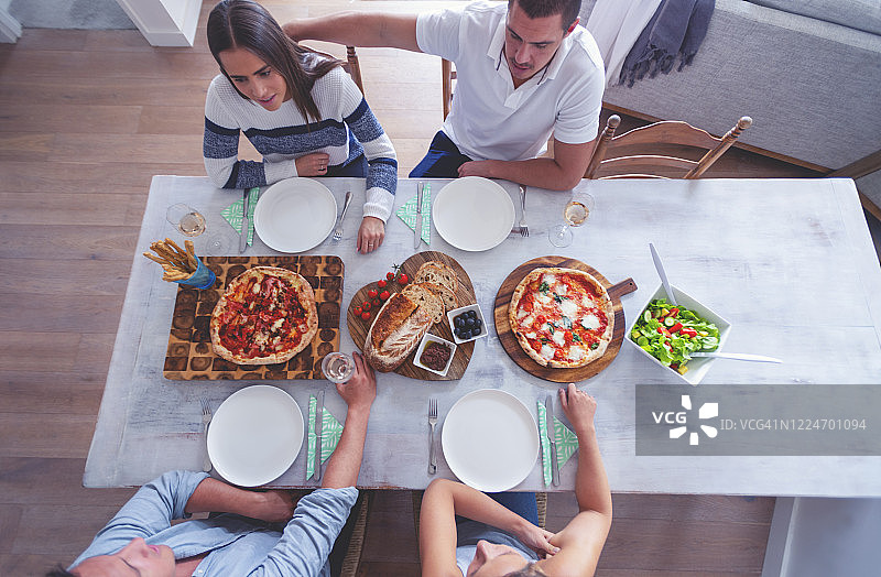 家人或朋友坐在餐桌前摆好带走的食物。图片素材