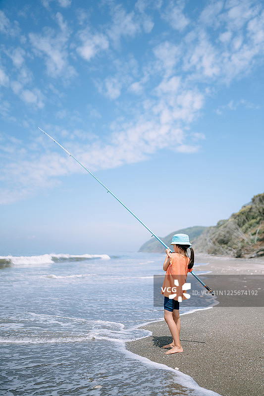 小女孩在东京湾的海滩上钓鱼图片素材