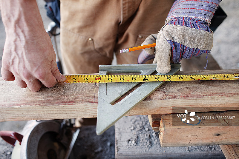 男性建筑工人测量木材切割的特写图片素材
