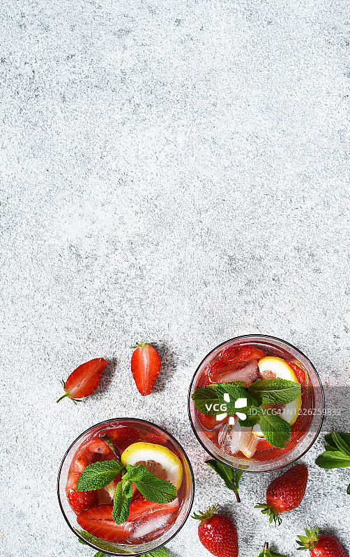 柠檬水，草莓和薄荷在混凝土背景。从以上观点。夏天冷饮。图片素材