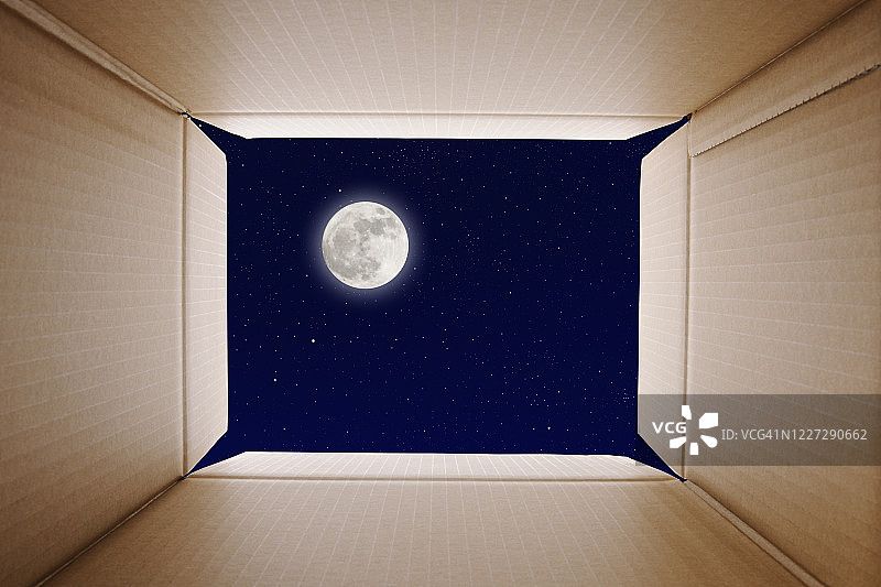在满月的夜晚，从纸箱里看到的景象图片素材