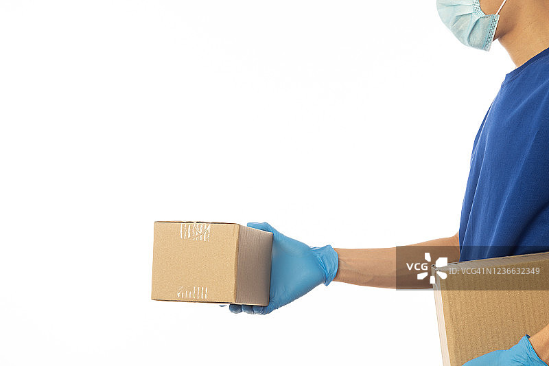 送货员手拿医用手套，戴口罩，手持纸板箱隔离在白色背景上，送货服务理念图片素材