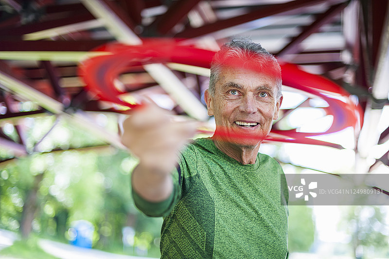 微笑活跃的老人在公园的凉亭拿着塑料圆盘图片素材