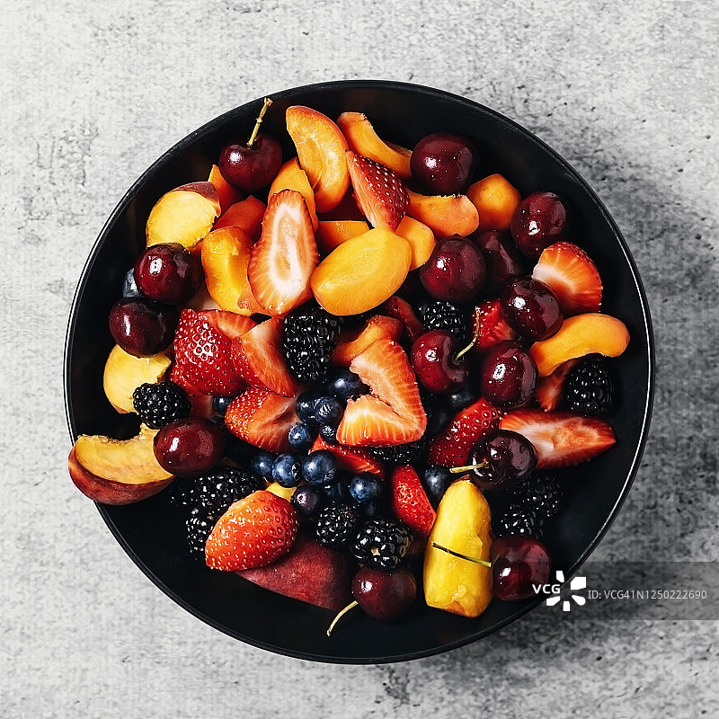 灰色背景上的一碗新鲜水果图片素材