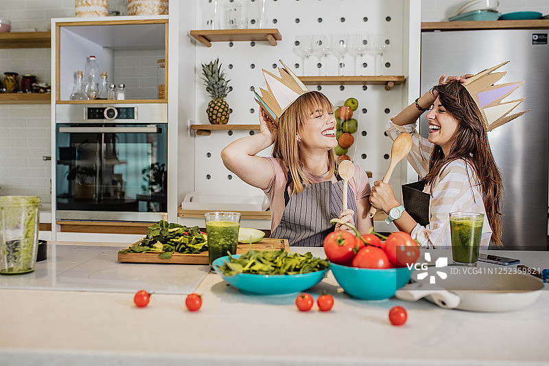 两个年轻的女性朋友有乐趣在厨房图片素材