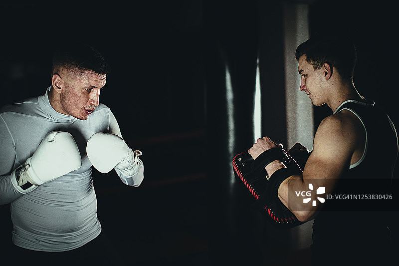两名男子在体育馆进行拳击训练图片素材
