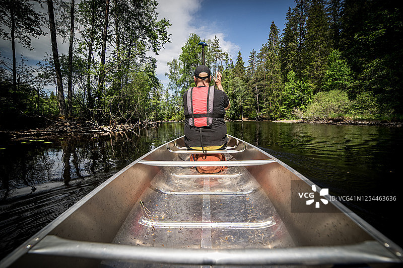 在荒野的河上划独木舟的人图片素材
