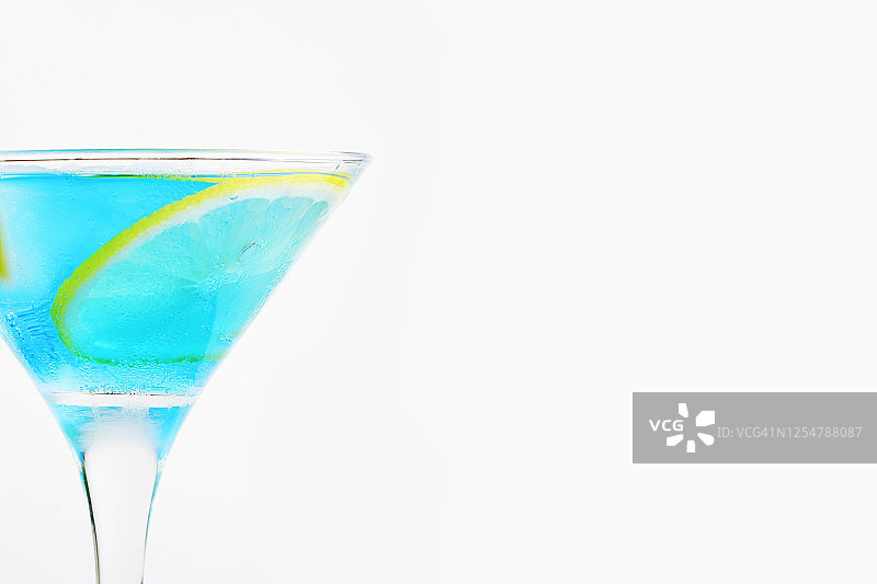 一杯清凉的蓝色鸡尾酒，加冰和一片柠檬。清爽的夏季酒精和非酒精饮料。本空间图片素材