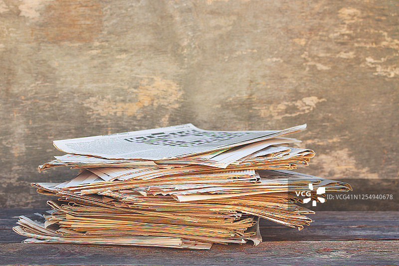 旧木头背景上的报纸和杂志。图片素材