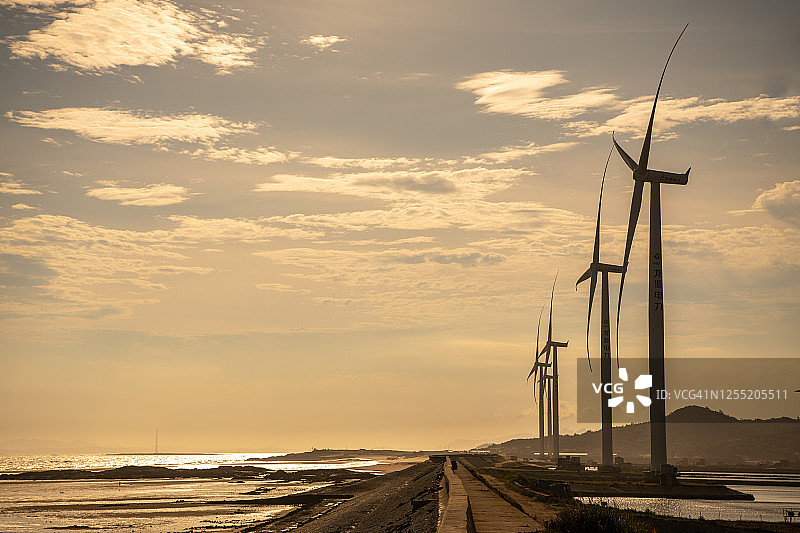 风力发电站在日落的海边图片素材
