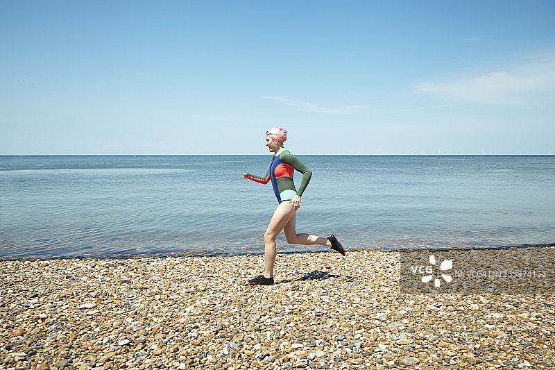 成熟的女人在海岸线上奔跑图片素材