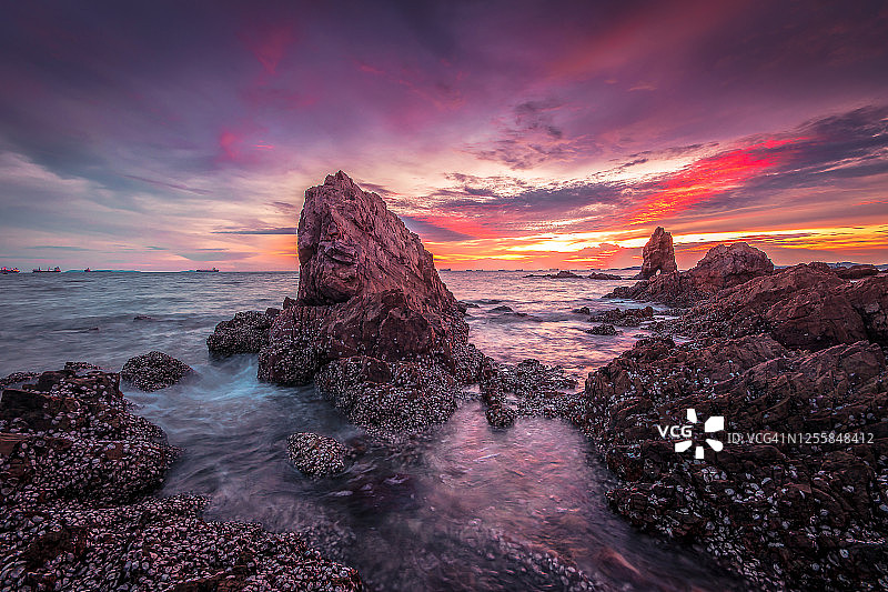 日落时，海滩上的岩石形成的风景图片素材