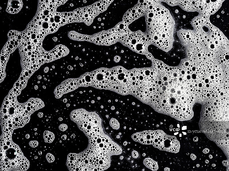 由黑色背景上的肥皂泡形成的纹理的完整框架。图片素材