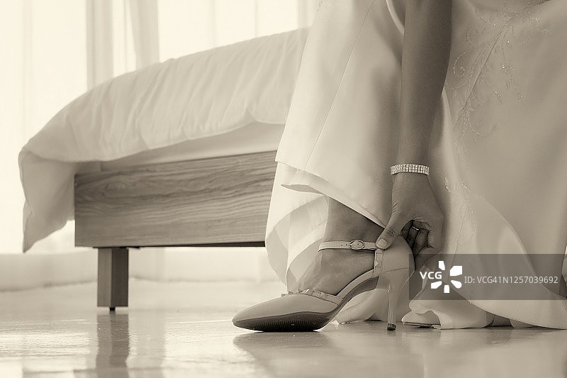近距离的复古风格的照片，一个新娘穿着一只鞋在白色的卧室图片素材