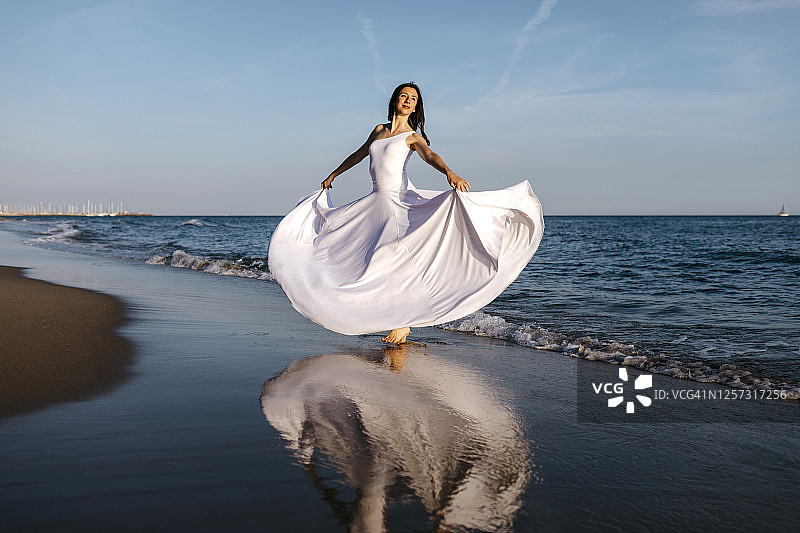 穿着白色裙子的芭蕾舞者在海上跳舞图片素材