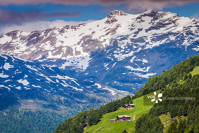 意大利阿尔卑斯山瓦尔富尔瓦的斯特尔维奥国家公园，雪山覆盖着小屋和谷仓图片素材