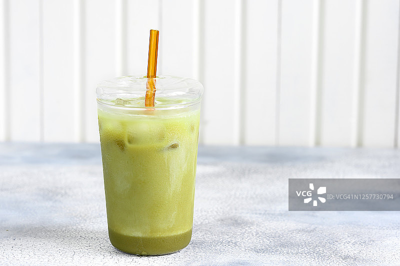 一杯抹茶绿茶冰拿铁加杏仁奶。灰石的背景。图片素材