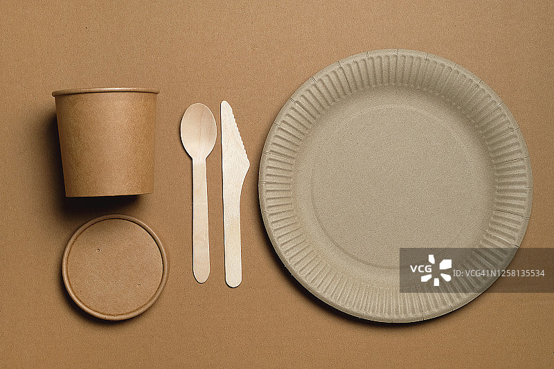 用可回收材料制成的一次性环保餐具，放在米色背景或桌子上。食品行业。图片素材