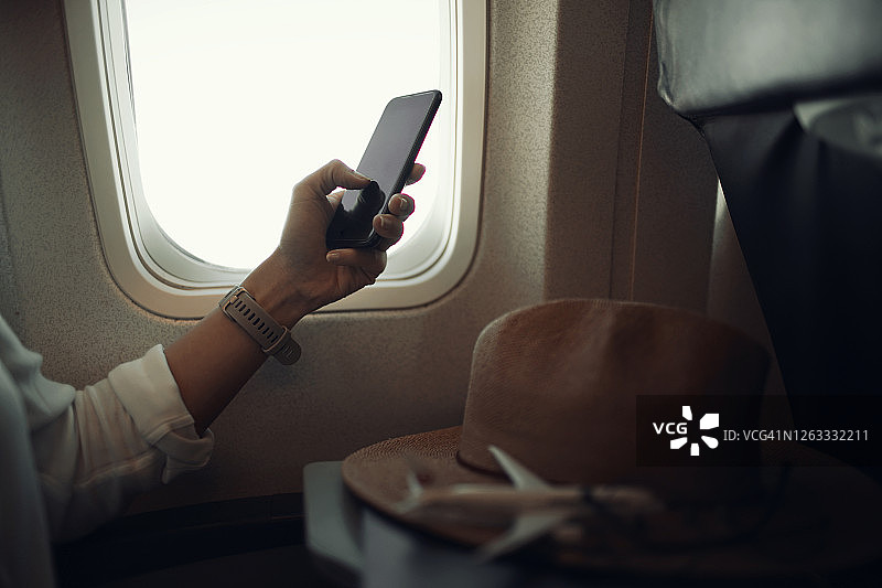 近距离观察旅客在飞机上使用手机的情况图片素材