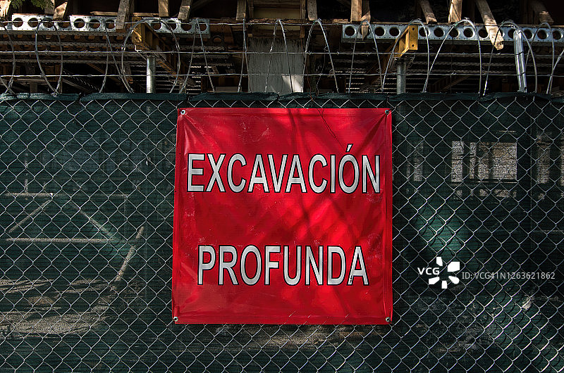 工地铁丝围栏上的“Excavación profunda”(深挖)警告标志图片素材